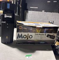 Spin Master III fixture standing beside original box