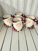 four ceramic Santa mugs front view