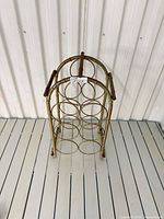 Front view of metal wine rack showing eight circular holders and arched top