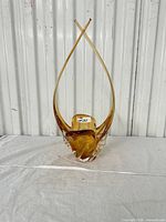 Front view of amber and clear sculptural glass vase showing crossed points and amber core