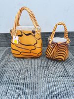Front view of both swirled amber glass handbag vases showing size difference and pattern