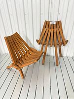 Pair of wooden slatted chairs, one opened for display and one folded to show collapsible form