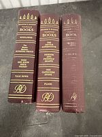 Spines of three burgundy Reader's Digest Condensed Books showing titles and gilt decoration