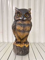 Full view of owl statue on stump base