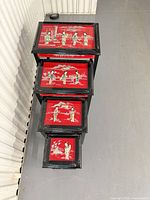 Top view showing all four stacked tables with red lacquer panels and relief figures