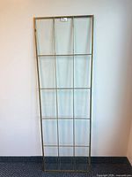 Full view of tall brass-framed 15-pane window sash