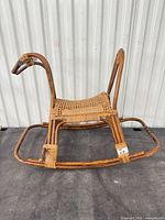 Left side view of rattan wicker rocking horse showing overall structure and finish