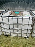 Front view of plastic tote in steel cage, lid visible