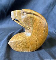 Right side profile of brown stone eagle head carving