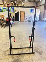 Front view of full squat rack showing pull-up bar, dip handles, and base
