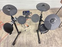 Full view of assembled AODSK electronic drum kit with rack, pads, module, headphones, cables