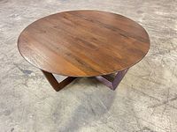 Angled view of entire round coffee table showing top surface and base