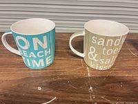 two beach-themed mugs side view