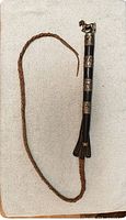 Full view of whip showing handle, lash and tassel