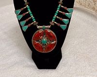 Front view of necklace on black display showing pendant, fan drops, bead strands