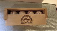 Wooden display case partially open revealing four autographed baseballs