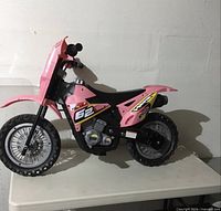 Left side view of pink G2 62 ride-on dirt bike