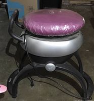 full view of machine showing base, body, seat and power cord