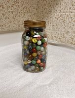 Full view of jar filled with assorted marbles