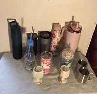 Assorted bottles, tumblers, mugs, onyx goblets and stainless mugs