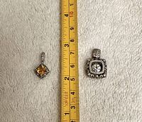 Both pendants beside ruler for scale