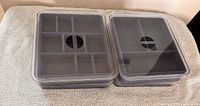 Two jewelry trays with compartment layouts and clear lids displayed side by side