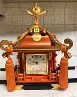 Front view showing dial, tassels, shrine detailing and phoenix finial