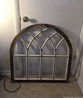Front view of arched wood window frame showing design and color