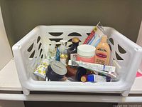 Basket containing mixed lotions, creams, oils, toothpaste, toothbrushes