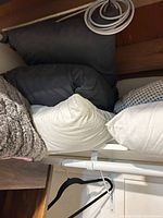 Stack of faux fur blanket, charcoal pillow and white pillow on shelf