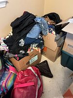 Boxes and tote overflowing with assorted women’s plus size clothing