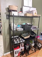 Overall view of metal shelving with bakeware, glass dishes, small appliances and boxed items