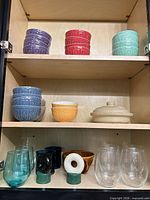 Cabinet view showing full assortment of bowls, casserole, glasses and napkin rings