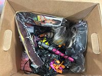 Box containing wigs, Kanekalon hair pack, curling wand and perm rods