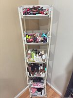 Full stand showing five shelves filled with assorted makeup and skincare items