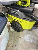 Ryobi cordless wet/dry vacuum showing body, wheel, hose connection and colour scheme