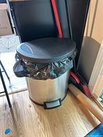 Stainless steel trash can with foot pedal and black lid