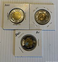 Front view of all three $2 coins in flips showing years 1999, 2020, 2021