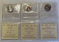 Front view of three graded coins in ICCS flips showing coin designs and certification labels