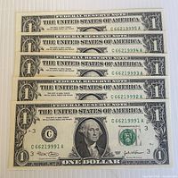 Front view of five sequential 2003 $1 bills arranged in stack