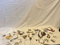 Full lot overview showing quantity and variety of jewelry pieces laid out