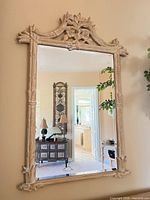 Full view of vertical mirror on wall showing carved bamboo frame and overall condition