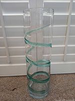 Full view of cylindrical glass vase showing aqua spiral accent