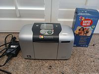Printer with power adapter and sealed paper pack on countertop