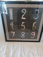 Full front view of framed print showing numerals and nude figure