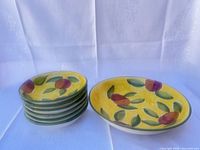 Stack of six small bowls beside one larger serving bowl showing pattern and exterior color