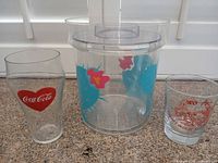 Front view of all three items: ice bucket with cactus print, Coca-Cola pint glass and Wo Fat shot glass