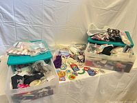 Overall view of three storage bins filled with trims, ribbons, cords and table display of embroidered patches