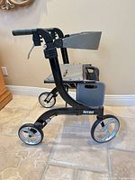 Left side view showing frame, seat, storage bag, wheels and hand brakes