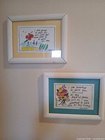 Both framed prints hanging on wall